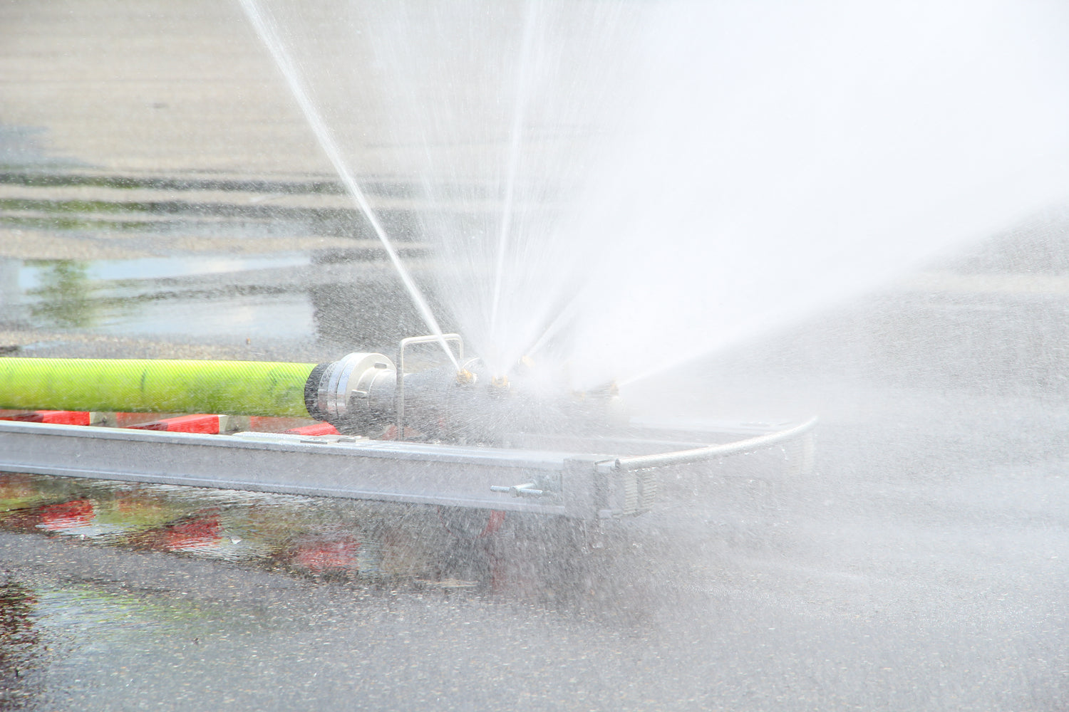 Feuerwehr Löschigel auf einer DIN-Steckleiter befestigt wie der Löschigel mit den feinen Düsen einen Sprühnebel zur Brandbekämpfung erzeugt.